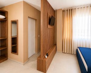 a room with a bed and a tv and a window at Nova Rooms Velipojë in Velipojë