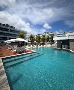 a large swimming pool with chairs and umbrellas at Cobertura 435 - In mare bali in Parnamirim
