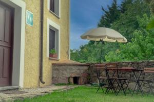 a table with an umbrella next to a building at Casa del Sur El Collau in Porrúa