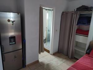 a room with a refrigerator and a shower in a room at Studio Les Avirons centre ville in Les Avirons