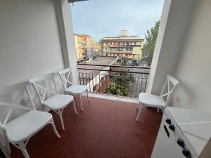 a balcony with chairs and a view of a city at SeaMood Casa Vacanze in Praia a Mare