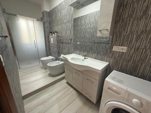a bathroom with a sink and a toilet and a washing machine at SeaMood Casa Vacanze in Praia a Mare +8 photos