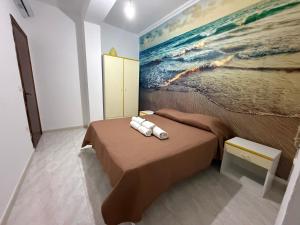 a bedroom with a bed with a painting on the wall at SeaMood Casa Vacanze in Praia a Mare