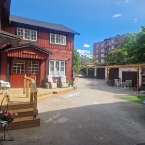a red building with a deck in front of it at Central City Apartment A in Nyköping