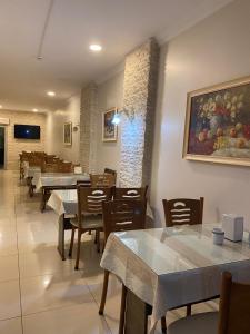 a restaurant with tables and chairs and a painting on the wall at Kiraz Otel in Lapseki