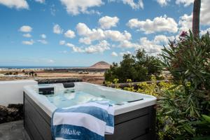 a soaking tub with a view of the beach at Villa Lore by Villalize in Teguise +77 photos