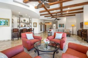 a living room with red chairs and a table at Palmilla Golf and Beach Villa in San José del Cabo