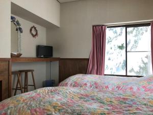 a hotel room with a bed and a window at North Point Lodge in Minami Uonuma