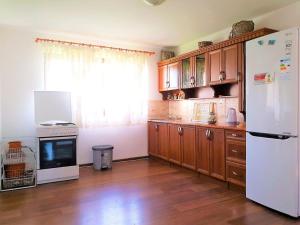 a kitchen with a white refrigerator and wooden cabinets at Ilidza Holiday Home in Sarajevo +12 photos