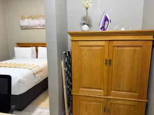 a bedroom with a wooden cabinet next to a bed at Angel Guest House in Maputo
