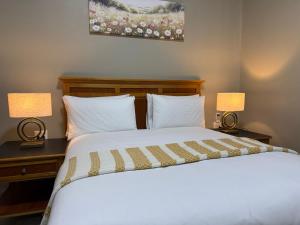 a bedroom with a bed and two lamps on tables at Angel Guest House in Maputo