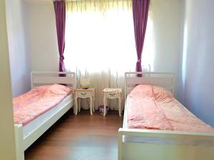 two beds in a room with a window at Ilidza Holiday Home in Sarajevo