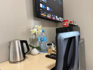 a desk with a computer monitor and a coffee maker at Angel Guest House in Maputo