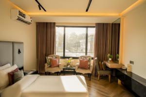 a hotel room with a bed and a living room at City Hotel in Abbottabad