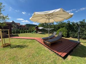 a patio with two chairs and an umbrella at Szivike Vendégház in Ábrahámhegy