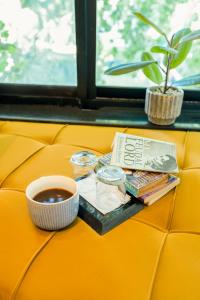a cup of coffee and books on a yellow couch at City Hotel in Abbottabad +32 photos