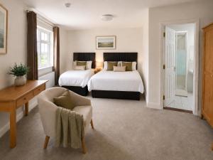 a hotel room with two beds and a chair at Renard Lodge in Cahersiveen