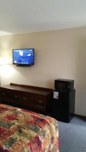 a hotel room with a bed and a flat screen tv on the wall at Foster Inn Monticello in Monticello