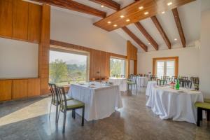 a conference room with tables and chairs and a screen at The Corbett Greens- A Wild Resort Muhaan in Tota Ām