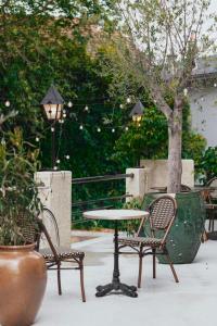 a table and two chairs and a table and a tree at Savoy Hotel in Le Bourget-du-Lac