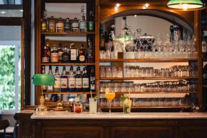 a bar with many glasses and bottles of alcohol at Savoy Hotel in Le Bourget-du-Lac