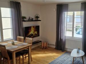 a living room with a table and a fireplace at Central City Apartment A in Nyköping