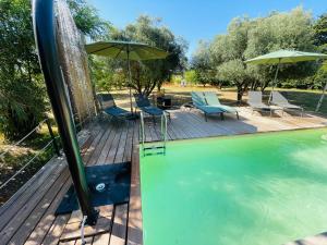 a swimming pool with chairs and an umbrella at Batisse de vacance cadre exceptionnel in Fréjus