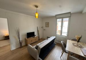 a living room with a couch and a television at T2 Calme et Moderne in Margny-lès-Compiègne