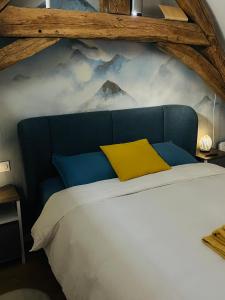 a bed with a blue headboard and a yellow pillow at Villa Ô Bedroom2 studio entier in Chasnay