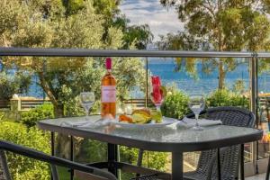 a table with a bottle of wine and glasses on a balcony at Evia Riviera Resort by Anayia All Inclusive Resorts in Amarynthos +29 photos