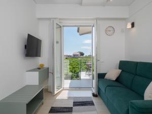 a living room with a green couch and a sliding glass door at B&B CASA VACANZA ETHOS il POSTO DA VIVERE in Casa Boscarelli