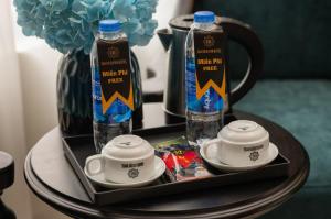 a table with two cups and two bottles of water at Grand Luxury Hotel Bắc Ninh in Chu Mẫu
