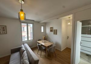a living room with a couch and a table at T2 Calme et Moderne in Margny-lès-Compiègne