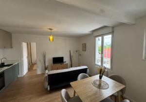 a living room with a table and a couch at T2 Calme et Moderne in Margny-lès-Compiègne