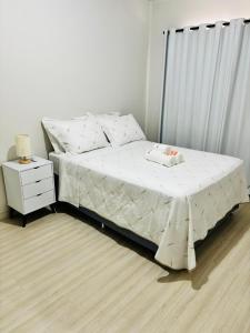 a bed in a bedroom with a nightstand and a bed sidx sidx at Apartamento 2 quartos e 2 camas casal in Cascavel