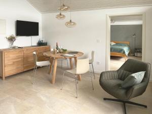a living room with a table and chairs and a television at nava-suites - 2-Zi-Appartement mit Naheblick mitten in Bad Kreuznach in Bad Kreuznach