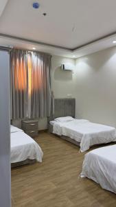 a bedroom with two beds and a window at شقق تاج اليرموك الفندقية in Tabuk