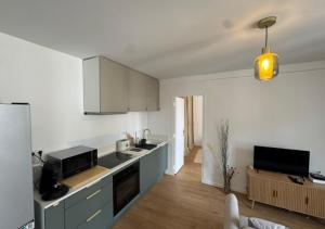 a kitchen with white cabinets and a white refrigerator at T2 Calme et Moderne in Margny-lès-Compiègne