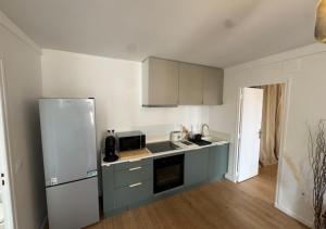 a small kitchen with a refrigerator and a sink at T2 Calme et Moderne in Margny-lès-Compiègne +2 photos
