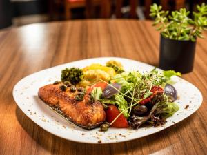 a white plate of food on a wooden table at ibis Betim in Contagem