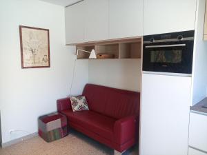 a living room with a red couch in a kitchen at Klauwaards appartement in Kortrijk