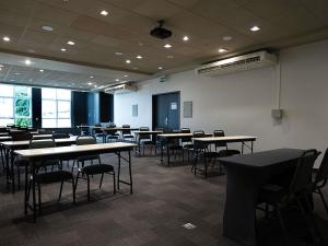 a room with tables and chairs in a classroom at ibis Caxias do Sul in Caxias do Sul