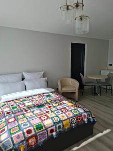 a bedroom with a bed with a colorful quilt on it at Jurgvita in Palanga