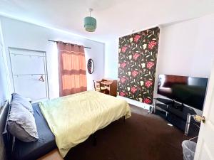 a bedroom with a bed and a flat screen tv at 1 Bed & Breakfast West Brom in West Bromwich
