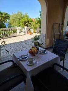 a white table with a plate of food on it at Apartments 3 Palms in Crikvenica