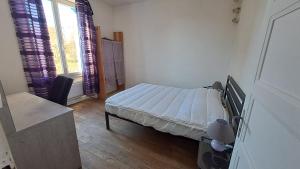 a small bedroom with a bed and a window at Les Centaurées in Égletons