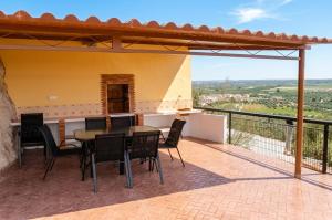 a patio with a table and chairs on a balcony at Casas Cueva con piscina y barbacoa in Fontanar