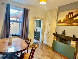 a dining room with a table and a fireplace at 1 Bed & Breakfast West Brom in West Bromwich
