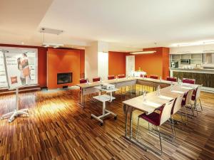 a conference room with tables and chairs and a screen at Ibis Praha Old Town in Prague