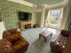 a living room with two couches and a television at The Dales in Marshside